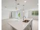 Kitchen island with stainless steel faucet and lighting. Open to living spaces at 2352 Citrus Bloom Dr, Bartow, FL 33830