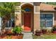 Inviting front door entrance with an arched entryway, landscaping, and beautiful potted plants at 2721 Village Pine Ter, Orlando, FL 32833
