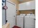 Functional laundry room with modern washer and dryer, and ample storage space at 2721 Village Pine Ter, Orlando, FL 32833