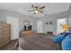 Well-lit main bedroom with a ceiling fan, large dresser, and en-suite bathroom at 6218 Forsythe Loop, Sanford, FL 32771