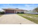 Home exterior featuring a long driveway leading to the attached garage at 947 N Atmore Cir, Deltona, FL 32725