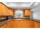 Well-lit kitchen boasts plentiful wood cabinets, dark countertops, and stainless microwave at 947 N Atmore Cir, Deltona, FL 32725