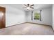 Bright main bedroom featuring neutral carpet and a window offering natural light and backyard views at 947 N Atmore Cir, Deltona, FL 32725