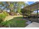 A spacious backyard features a screened-in patio and large shade tree at 1056 Royal Saint George Dr, Orlando, FL 32828