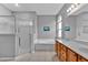 Well-lit bathroom features a glass shower, soaking tub, double vanity, and arched window at 1056 Royal Saint George Dr, Orlando, FL 32828