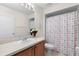 Bright bathroom with seashell-themed shower curtain, vanity with white sink, toilet, and a large mirror at 1056 Royal Saint George Dr, Orlando, FL 32828