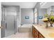 Bathroom features a soaking tub, glass-enclosed shower, double sink, and an arched window for natural light at 1056 Royal Saint George Dr, Orlando, FL 32828