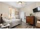 Well-lit bedroom with ceiling fan, wood-look flooring, vintage dresser, and neutral decor offers a cozy retreat at 1056 Royal Saint George Dr, Orlando, FL 32828