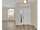 Bright foyer with white front door, sidelight window and modern flooring at 1056 Royal Saint George Dr, Orlando, FL 32828