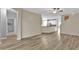 Open-concept living area features wood-look floors flowing into the kitchen and a view of the stairs at 1056 Royal Saint George Dr, Orlando, FL 32828