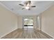 Bright living room with wood-look floors and sliding glass doors leading to a screened patio at 1056 Royal Saint George Dr, Orlando, FL 32828