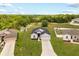 Aerial view of a well-kept home with a large green lawn, shed, and surrounding neighborhood with lush trees at 2257 Pecos Ct, Kissimmee, FL 34759