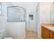 Bright bathroom featuring a glass enclosed shower, neutral tile flooring, and a sink with a wood cabinet at 2637 Shelby Ruth Pl, St Cloud, FL 34769