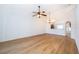 Open living room features wood floors, ceiling fan, and arched doorways to kitchen and entry at 2637 Shelby Ruth Pl, St Cloud, FL 34769
