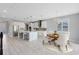 A modern dining area with white chairs, a wooden table, and bright chandelier sits adjacent to the kitchen at 2661 Estuary Loop, Oviedo, FL 32765