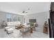 Inviting living room with a neutral color scheme, large windows, and cozy seating, perfect for relaxation at 2661 Estuary Loop, Oviedo, FL 32765