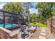 Beautiful backyard with a cozy patio area, fire pit, and a screened-in pool, surrounded by lush landscaping at 878 W Timberland Trl, Altamonte Springs, FL 32714