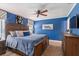Stylishly decorated bedroom with bold blue walls, wood furniture, and ceiling fan for added comfort at 878 W Timberland Trl, Altamonte Springs, FL 32714
