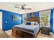 Cozy bedroom with blue accent wall, wood furnishings, ceiling fan, and decorative artwork create a welcoming space at 878 W Timberland Trl, Altamonte Springs, FL 32714