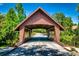 Scenic view of a covered bridge over a quiet road, surrounded by lush greenery and trees, offering a charming entrance at 878 W Timberland Trl, Altamonte Springs, FL 32714