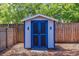 Backyard shed featuring a charming design with double doors, complemented by a well-maintained lawn and wooden fence at 878 W Timberland Trl, Altamonte Springs, FL 32714
