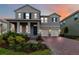 Charming two-story home with brick driveway, two-car garage, and manicured landscaping at sunset at 12805 Charmed Dr, Winter Garden, FL 34787