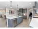 Spacious kitchen features an island with a sink, stainless steel appliances, and stylish pendant lighting at 12805 Charmed Dr, Winter Garden, FL 34787