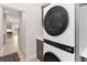 Convenient laundry area with new stackable washer and dryer, gray cabinets and view to the kitchen at 12805 Charmed Dr, Winter Garden, FL 34787