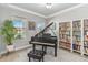 Bright living room showcasing neutral walls, modern flooring, piano, and a large bookshelf at 12805 Charmed Dr, Winter Garden, FL 34787