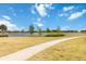 Scenic community view with a tranquil pond, walking path, and lush greenery on a sunny day at 12805 Charmed Dr, Winter Garden, FL 34787