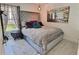 Comfortable bedroom featuring a gray headboard, artistic mirror, and a hanging light fixture at 1309 Rebecca Dr, Haines City, FL 33844
