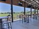 Beautiful covered patio dining area overlooking the golf course with tables, chairs, and multiple TVs at 1309 Rebecca Dr, Haines City, FL 33844