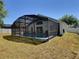 Backyard featuring a pool with screened-in enclosure and view of the lawn at 1309 Rebecca Dr, Haines City, FL 33844