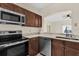 Contemporary kitchen with stainless steel appliances, dark cabinets, and eat-in bar at 1321 Arbor Vista Loop # 101, Lake Mary, FL 32746