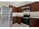 Modern kitchen featuring stainless steel appliances and wooden cabinets at 1321 Arbor Vista Loop # 101, Lake Mary, FL 32746