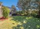 View of spacious backyard featuring a screened-in pool area, lush lawn, and decorative landscaping at 1450 Chessington Cir, Lake Mary, FL 32746