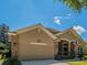 Charming home with a brick-accented facade, attached garage, well-maintained landscaping, and a visible American flag at 1450 Chessington Cir, Lake Mary, FL 32746