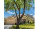 Attractive home featuring a well-manicured lawn, beautiful landscaping, and a inviting facade framed by a mature tree at 1450 Chessington Cir, Lake Mary, FL 32746