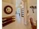 Inviting foyer features neutral tiling, modern light fixture, round mirror and wood furniture at 1450 Chessington Cir, Lake Mary, FL 32746
