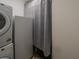 Functional laundry area with stacked washer/dryer unit and adjacent refrigerator at 1450 Chessington Cir, Lake Mary, FL 32746