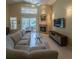 Bright living room with fireplace, large sectional, glass table, and access to outdoor patio at 1450 Chessington Cir, Lake Mary, FL 32746