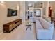 Spacious living room featuring neutral tiling, recessed lights, sectional and large television at 1450 Chessington Cir, Lake Mary, FL 32746
