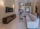 Open-concept living room with modern sectional sofa, sleek TV console, and neutral tile flooring at 1450 Chessington Cir, Lake Mary, FL 32746