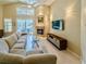 Living room with fireplace, tile floors, a ceiling fan, a sectional, and access to the back patio at 1450 Chessington Cir, Lake Mary, FL 32746