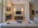 Cozy living room featuring a fireplace, comfortable seating, a glass table and warm neutral color palette at 1450 Chessington Cir, Lake Mary, FL 32746