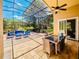 This covered patio includes an outdoor dining table, comfortable lounge furniture, and a ceiling fan at 1450 Chessington Cir, Lake Mary, FL 32746