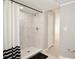 Bright bathroom featuring a tiled shower with a black and white shower curtain at 1475 Lowrie Ave, Orlando, FL 32805