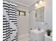 Bathroom featuring a tiled shower, vanity sink, and black and white shower curtain at 1475 Lowrie Ave, Orlando, FL 32805