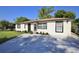 Charming home featuring a newer driveway, front lawn with plants and updated white exterior paint at 1475 Lowrie Ave, Orlando, FL 32805