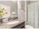 Well-lit bathroom featuring a granite countertop vanity and patterned shower curtain at 1628 Moon Valley Dr, Davenport, FL 33896